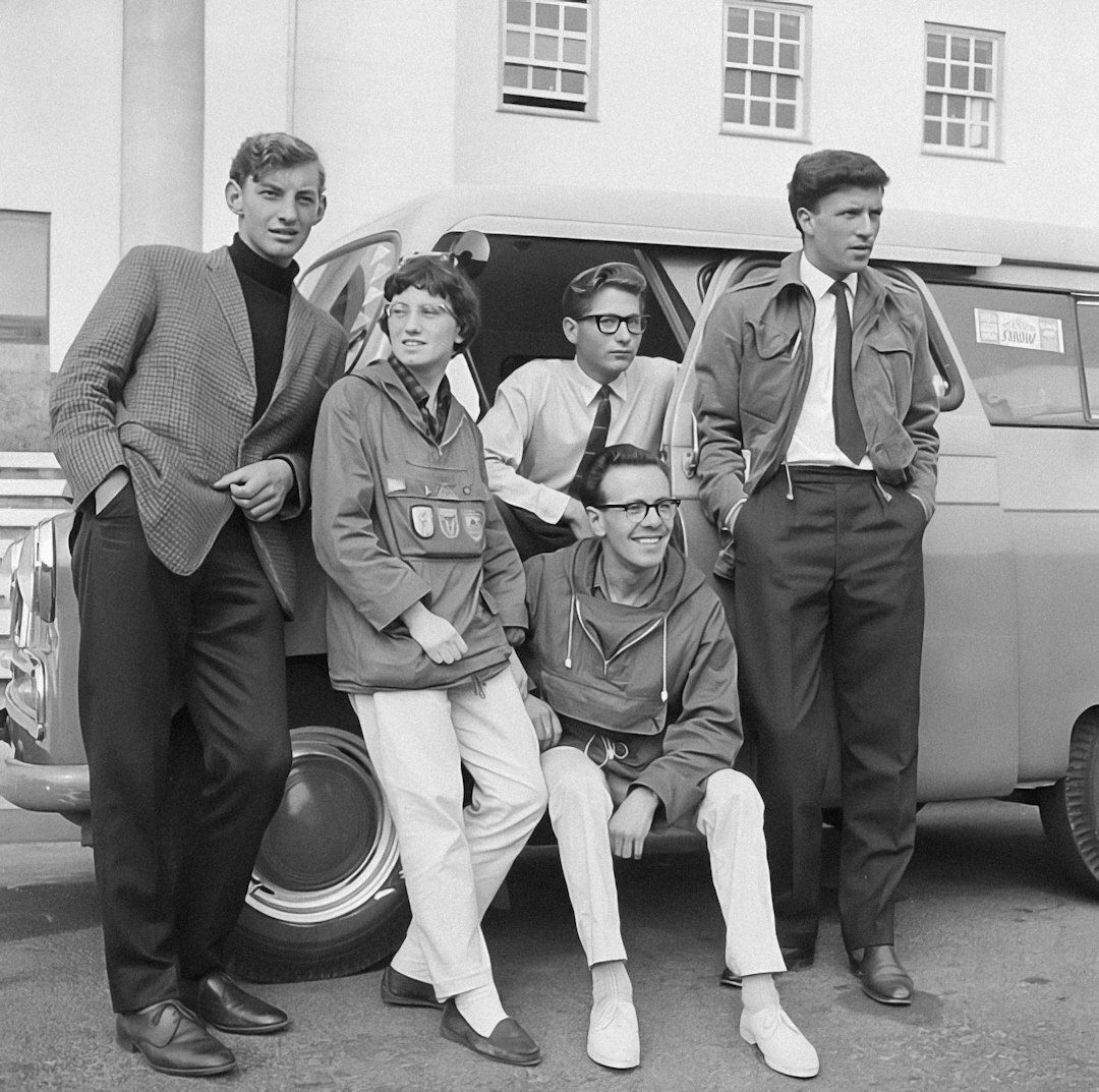 Team of broadcast engineers and technicians posing together in front of an outside broadcast van
